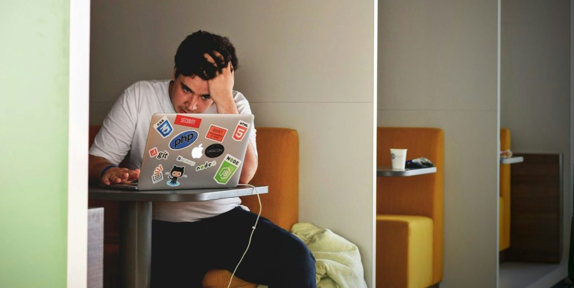man wearing white top using MacBook